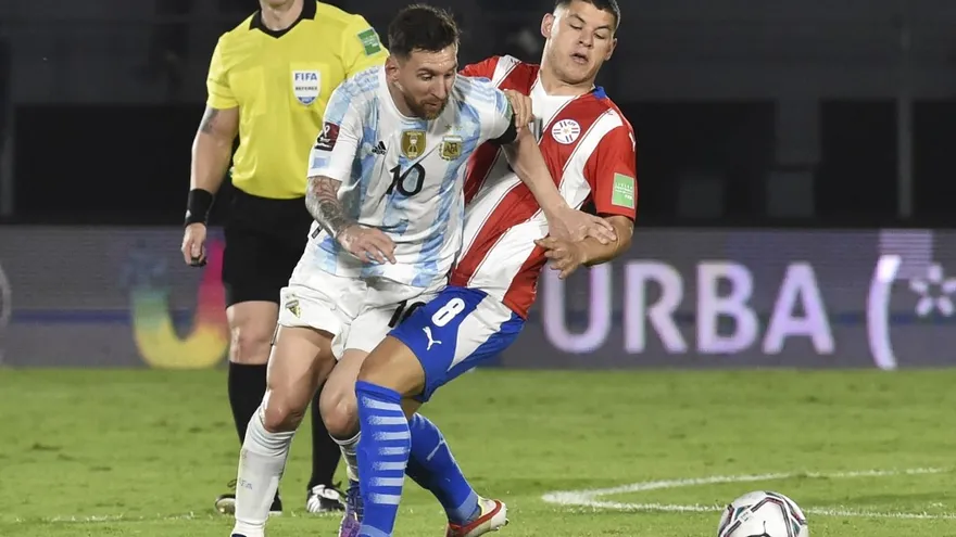 Lionel Messi disputando un balón ante la selección de Paraguay
