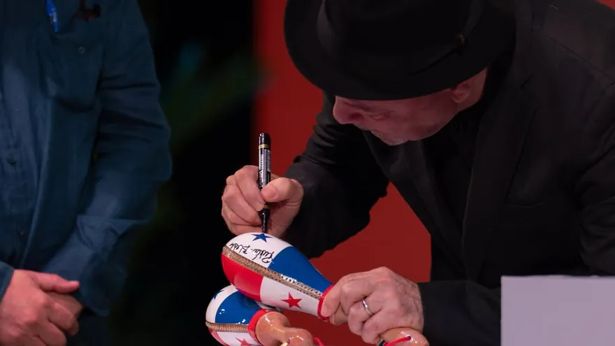 Rubén Blades firmando las maracas para entregarlas al Instituto Cervantes