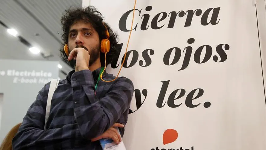 Un joven utiliza una cabina de audiolibros de la empresa Storyte durante la Feria Internacional del Libro de Guadalajara (FIL).