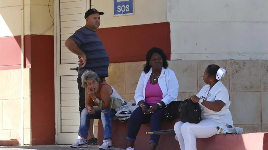 Vista de una doctora (c-d) y una enfermera (d) sentadas en el exterior del hospital Calixto García, hoy, miércoles 14 de noviembre del 2018, en La Habana (Cuba).