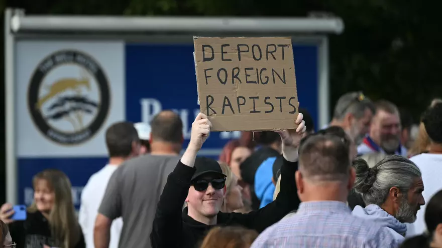 Un manifestante en Londres con una pancarta donde se lee "Deporten a los extranjeros violadores"