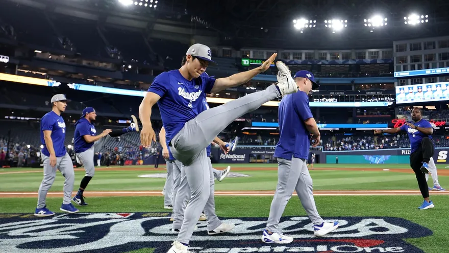 Jugadores de los Dodgers realizan ejercicios de calentamiento en el Rogers Centre de Toronto