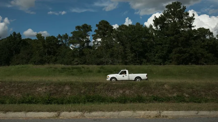 Un trabajador del condado conduce a lo largo de Lowery Street. A más de un millón de personas se les ordenó evacuar el camino del huracán.