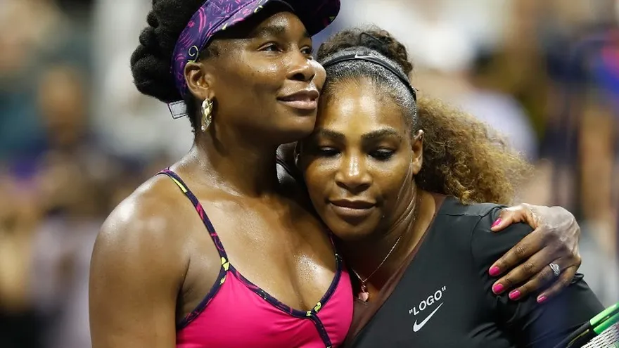 Serena (d) y Venus Williams se abrazan tras su partido en el US Open