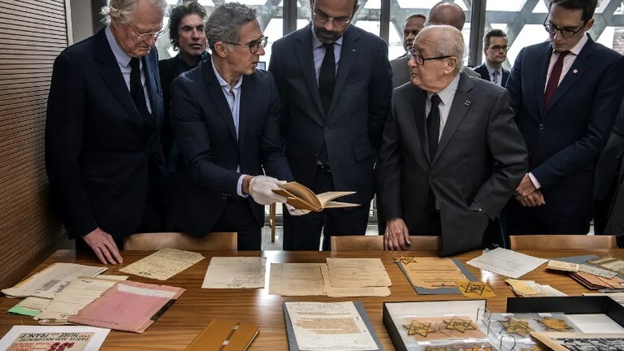 Personas observan documentos históricos en el  Memorial de la Shoah